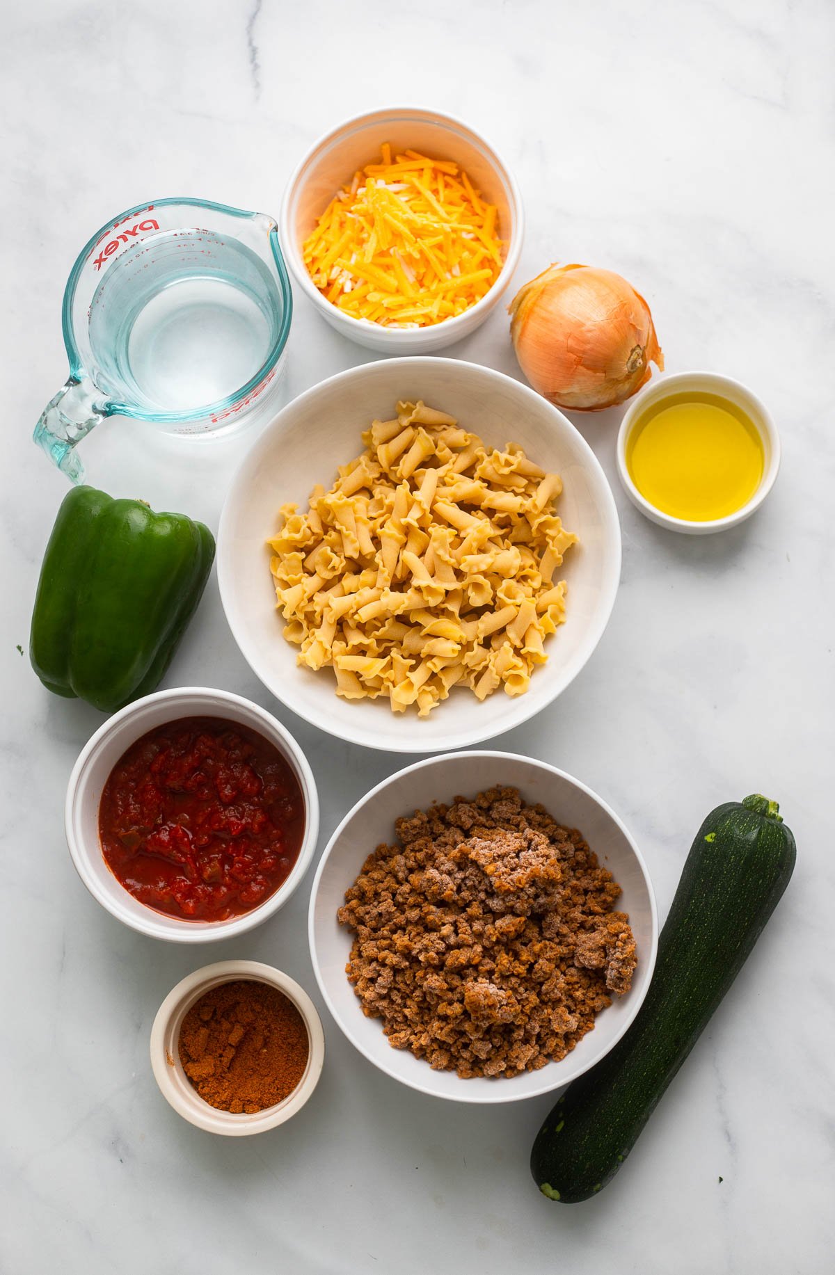 one pot vegan taco pasta ingredients in small bowls on a white background. 