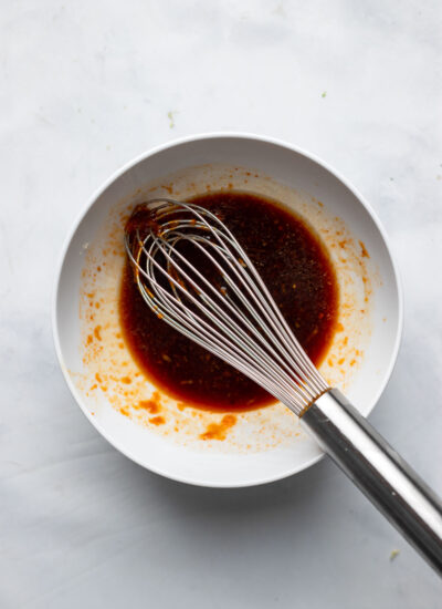 sticky sauce whisked together in a white bowl. 