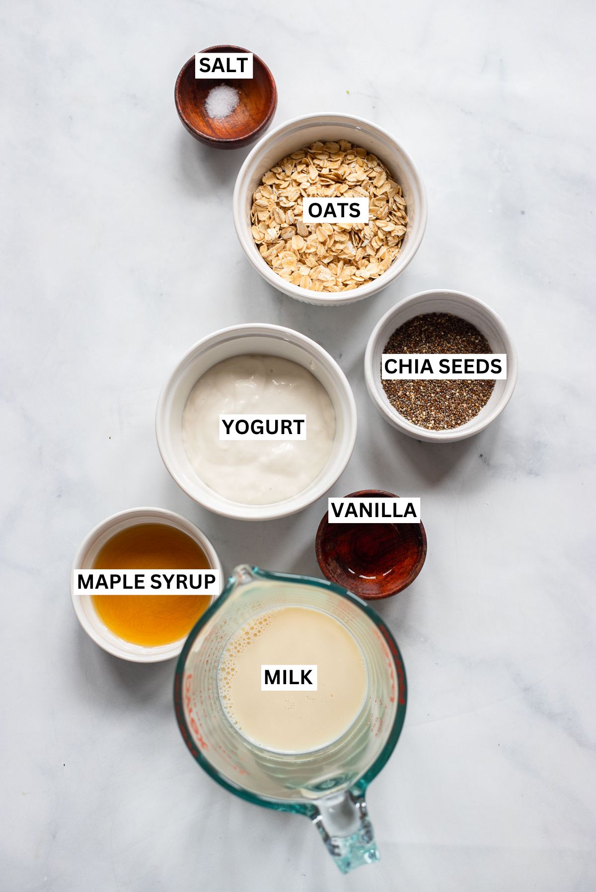 vegan overnight oats ingredients in small bowls with text overlay labels. 