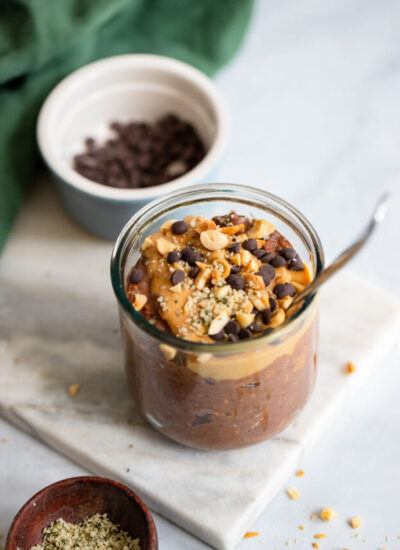chocolate peanut butter overnight oats in a glass jar with a spoon.