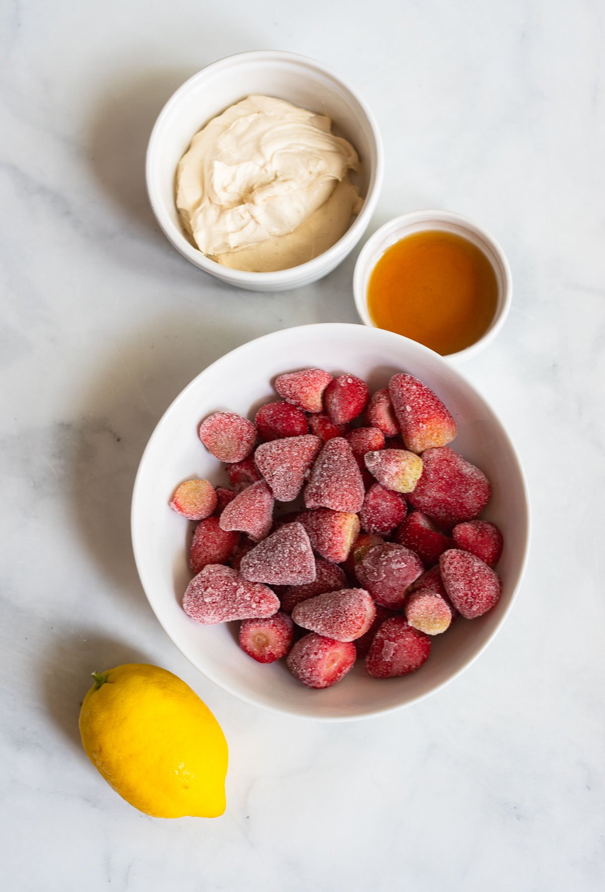 strawberry frozen yogurt ingredients in white bowls. 
