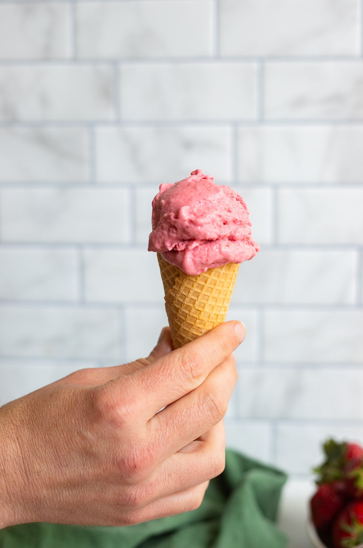 strawberry frozen yogurt in a sugar cone. 