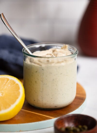 Tahini Caesar dressing in a glass jar with a spoon. 