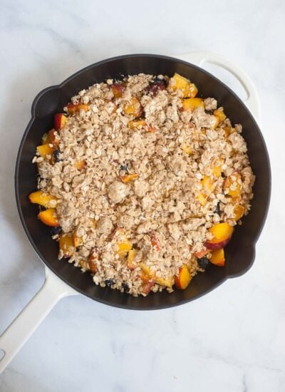assembled peach blueberry crisp in a skillet before baking. 
