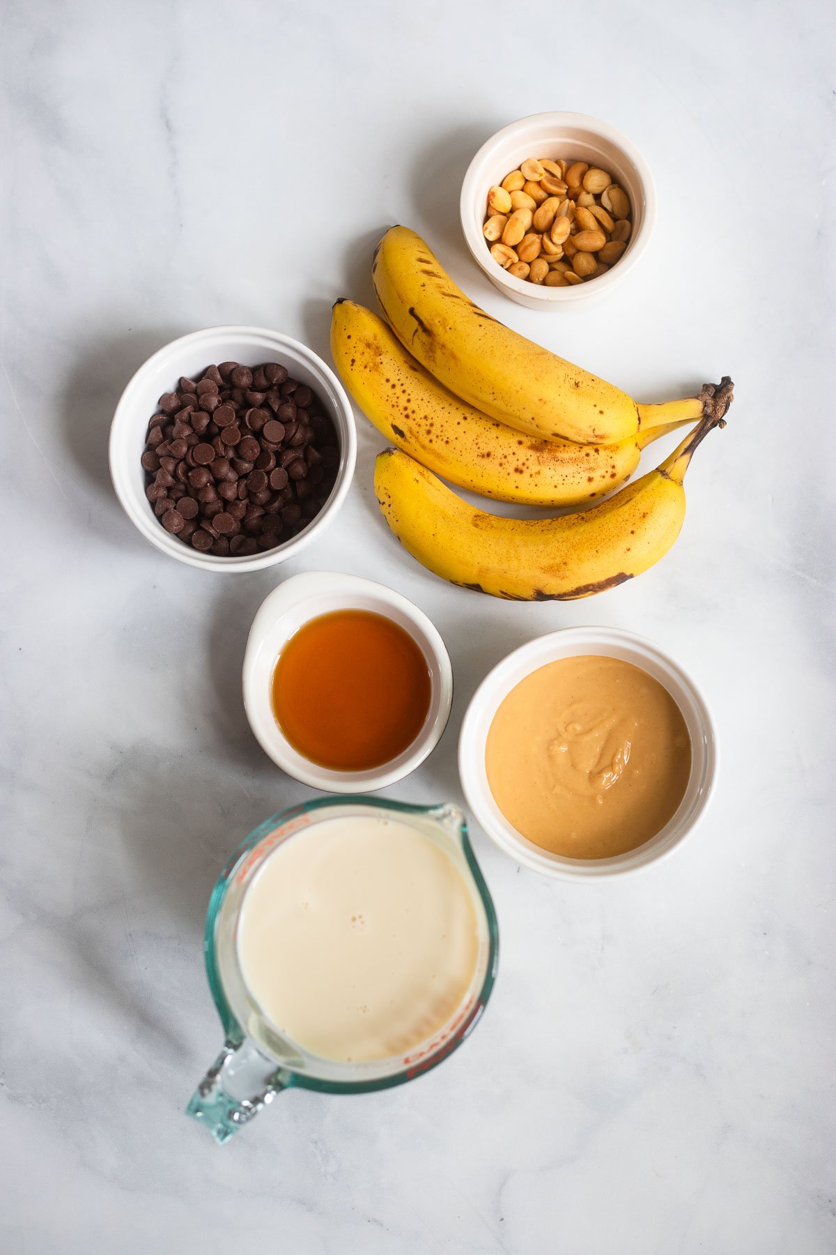 peanut butter banana popsicles ingredients laid out on a white background.
