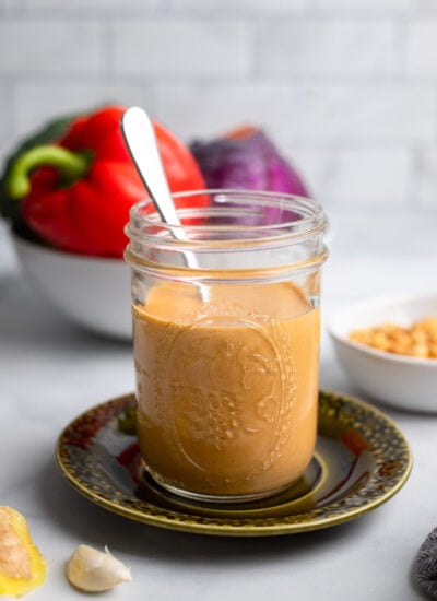 peanut butter stir fry sauce in a jar with a spoon.