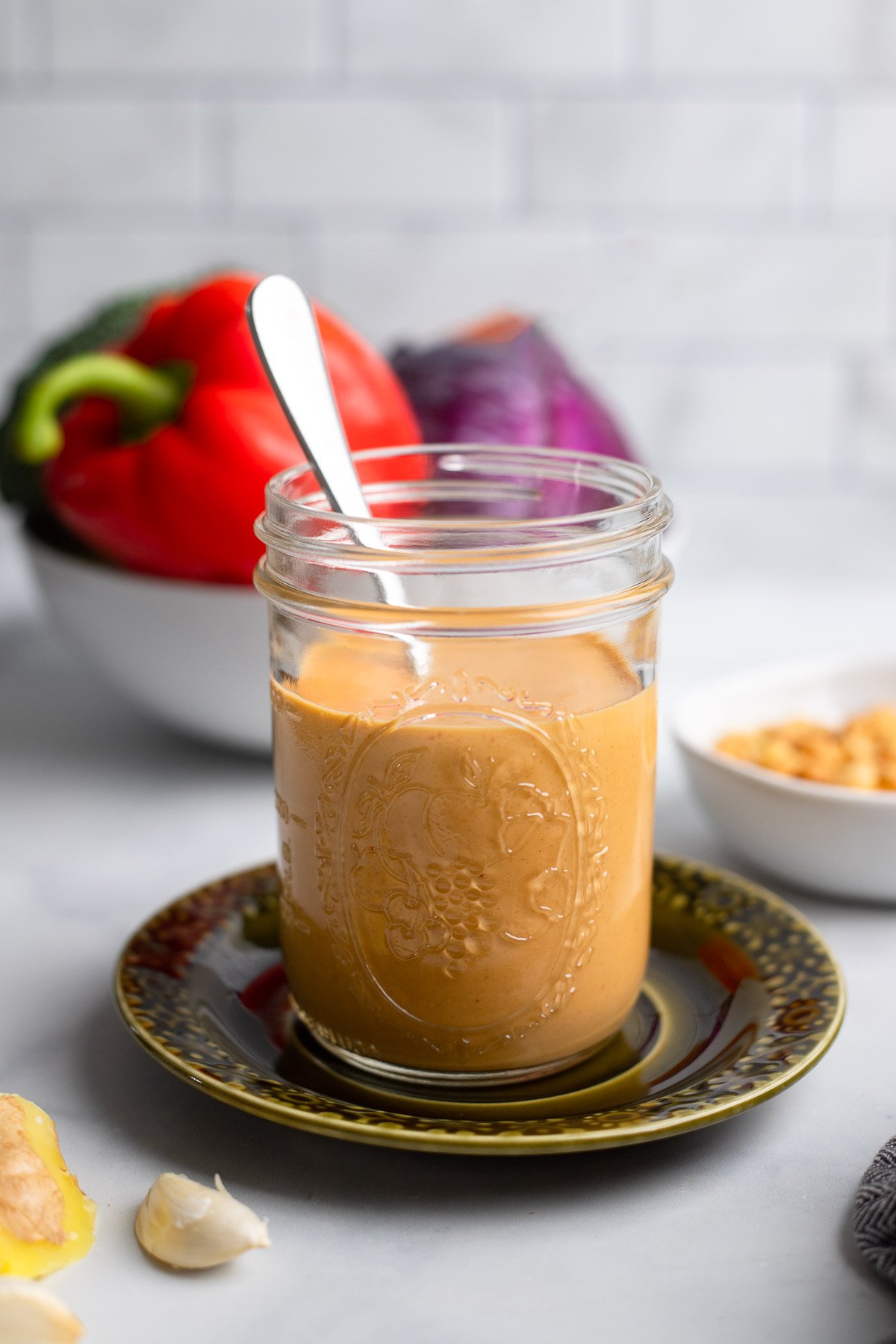 peanut butter stir fry sauce in a glass jar with a spoon.