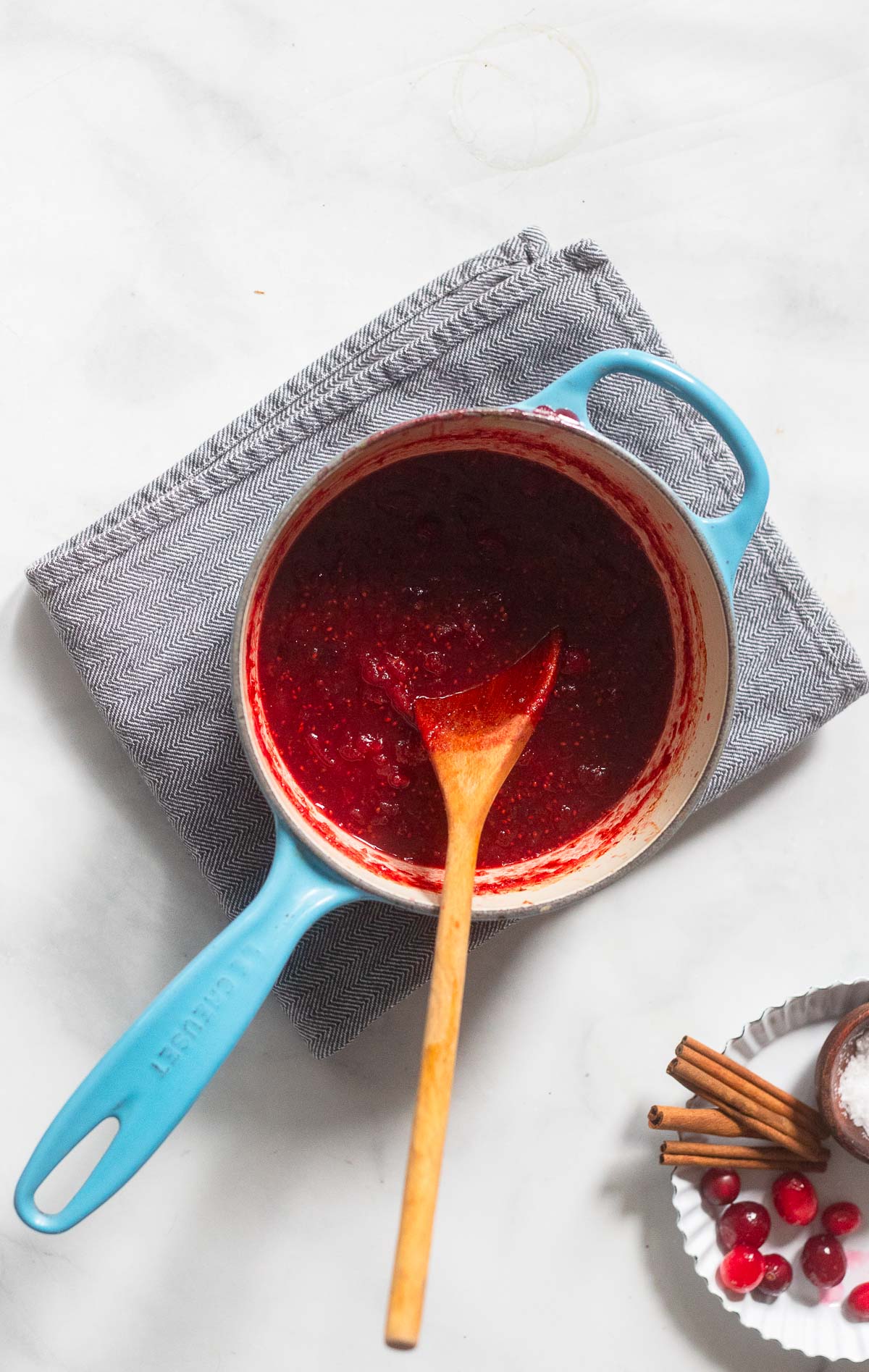 cranberry sauce in a saucepan with a wooden spoon. 