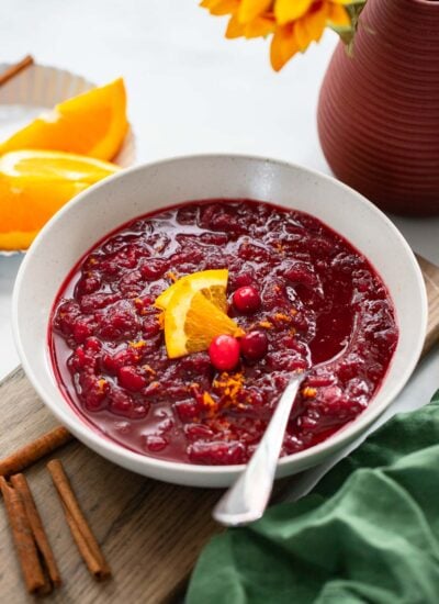 cranberry sauce in serving bowl garnished with orange wedges.
