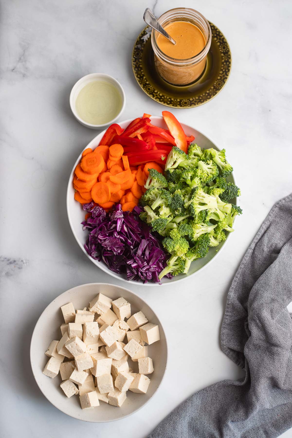 tofu stir fry ingredients in bowls on a white background. 