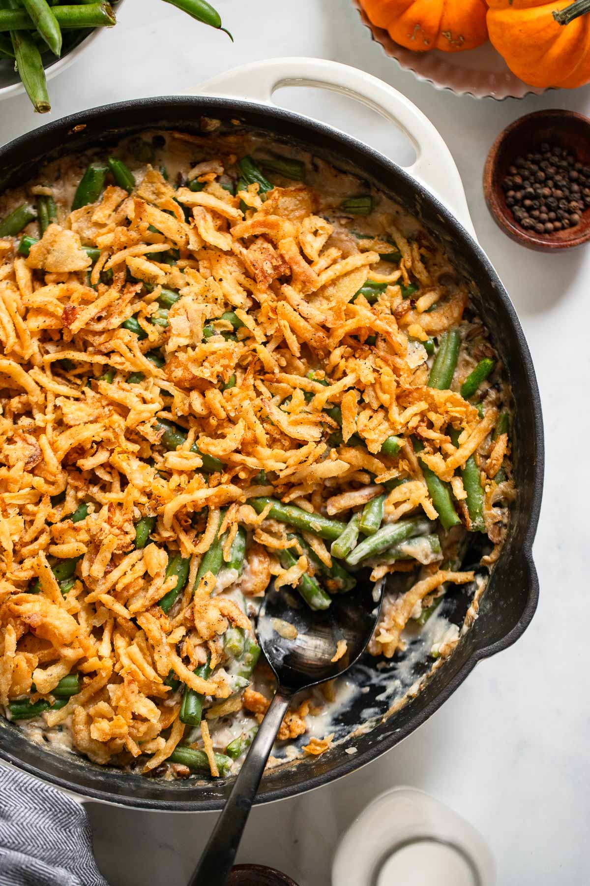 vegan green bean casserole in a skillet with a serving spoon.