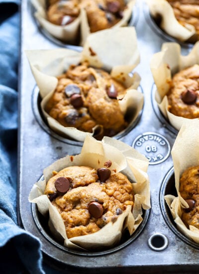 baked vegan pumpkin chocolate chip muffins in a muffin tin.