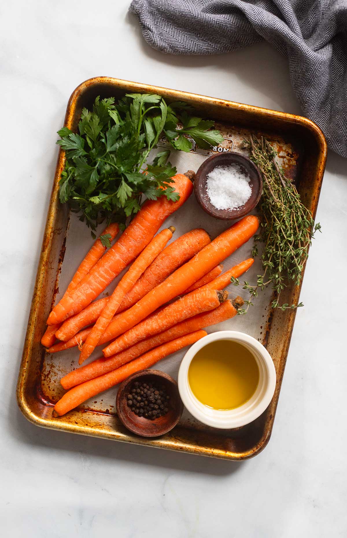 roasted carrot ingredients arranged on a baking sheet.