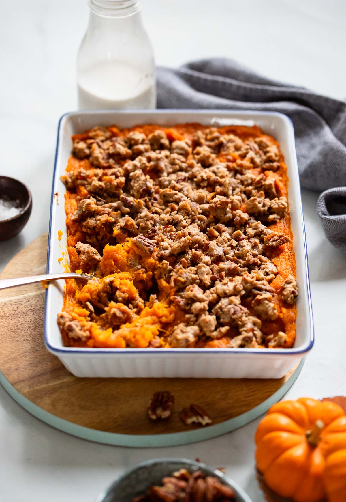 vegan sweet potato casserole in a baking dish with a serving spoon. 