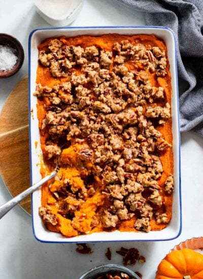 vegan sweet potato casserole in a baking dish with a serving spoon.