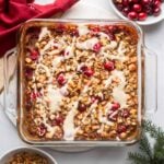 cranberry baked oatmeal topped with maple yogurt in a glass baking dish.