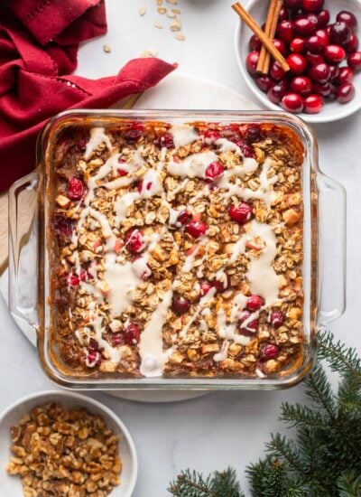 cranberry baked oatmeal topped with maple yogurt in a glass baking dish.
