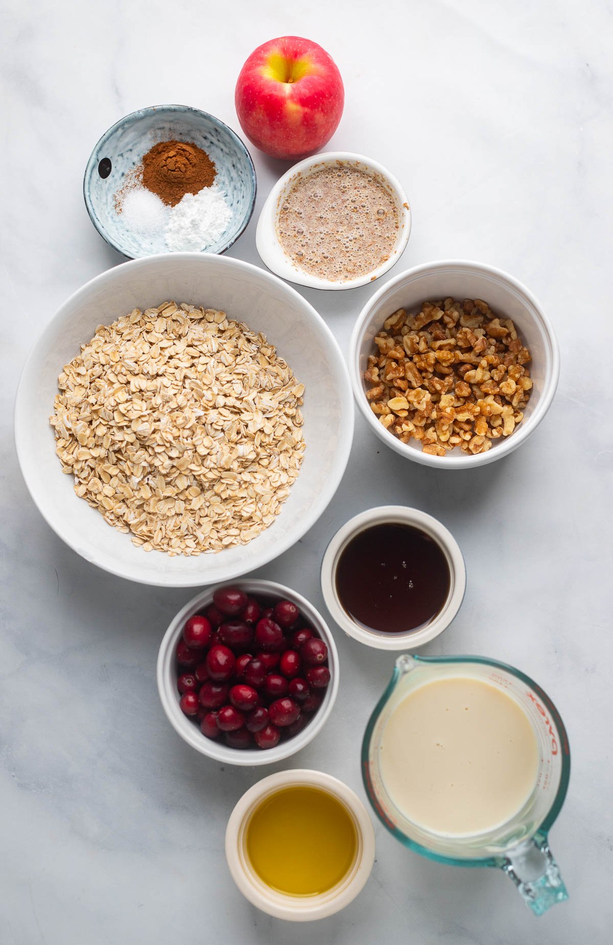 cranberry baked oatmeal ingredients in bowls on a white background. 