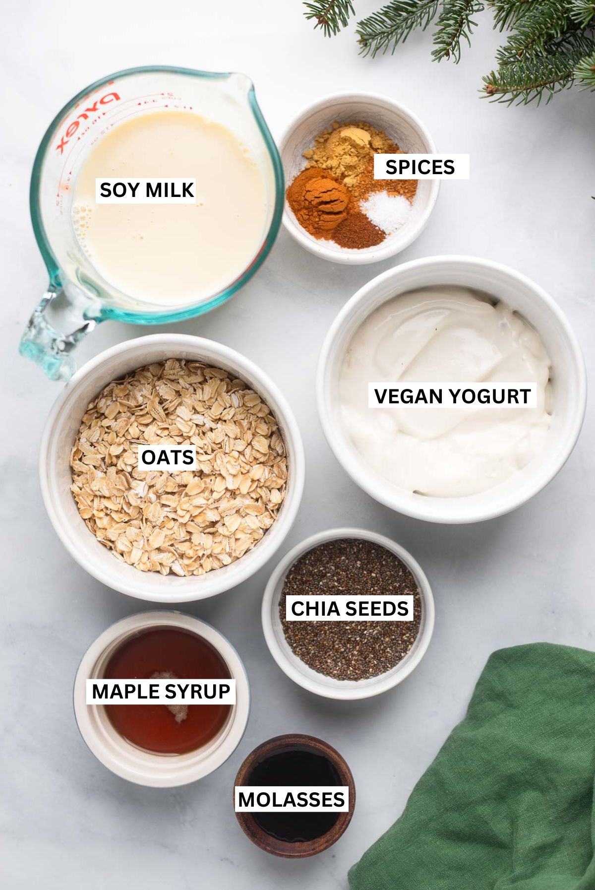 gingerbread overnight oats ingredients in small bowls on a white background with text labels.