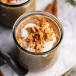 gingerbread overnight oats in a glass topped with crumbled cookies.