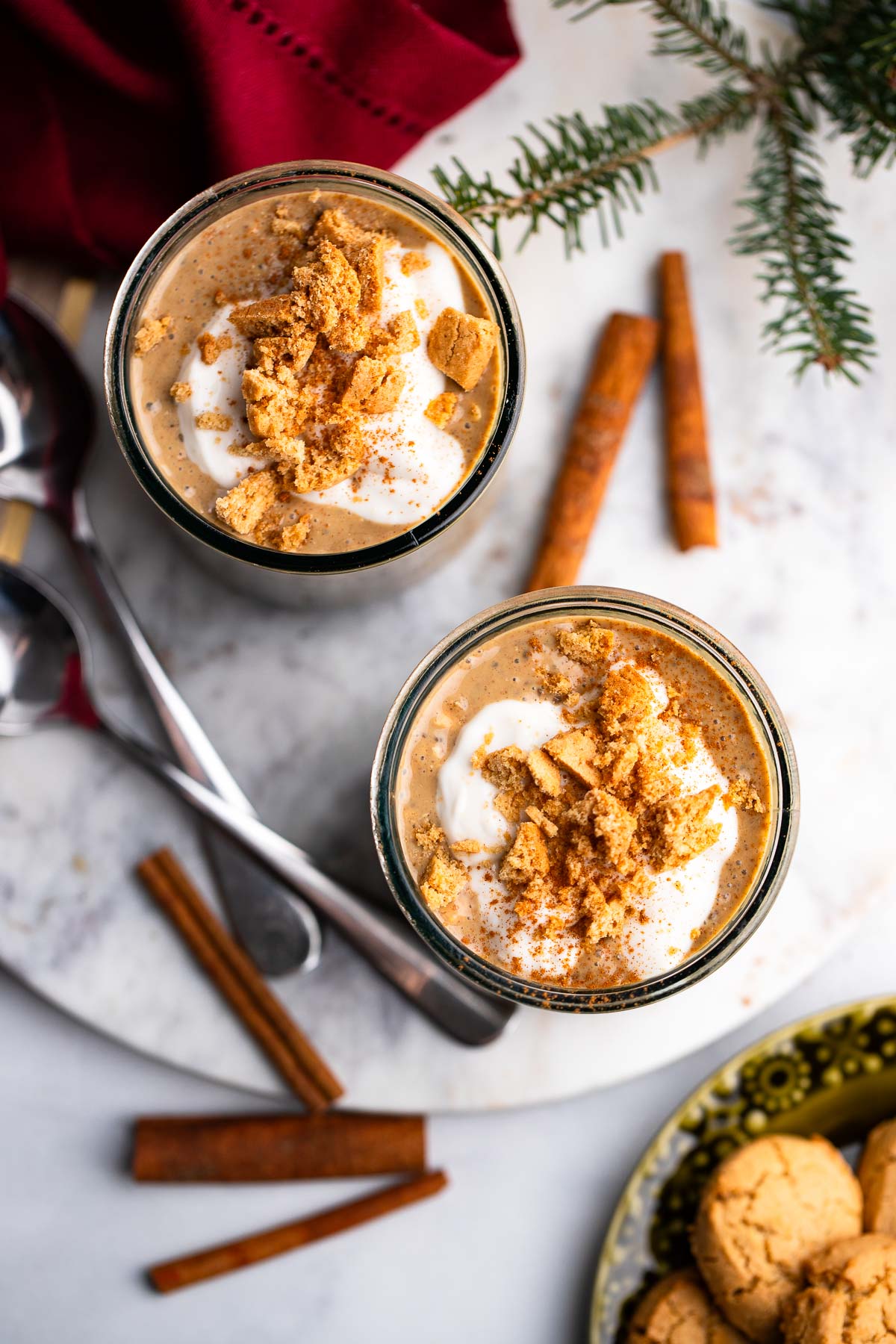 prepared gingerbread overnight oatmeal in two glass jars topped with crumbled cookies. 