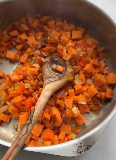 sweet potatoes, onion, and pepper sautéed in a skillet.