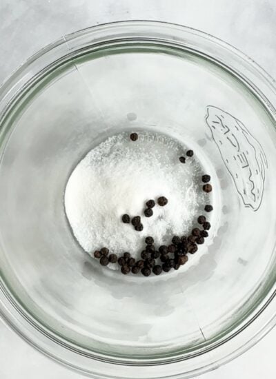 salt, sugar, and black peppercorns in the bottom of a jar. 