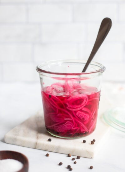 quick pickled red onions in a jar with a fork.