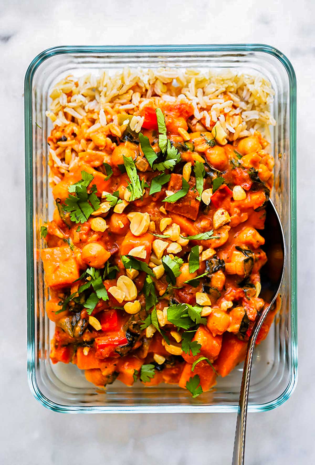 sweet potato chickpea curry in a glass meal prep container. 
