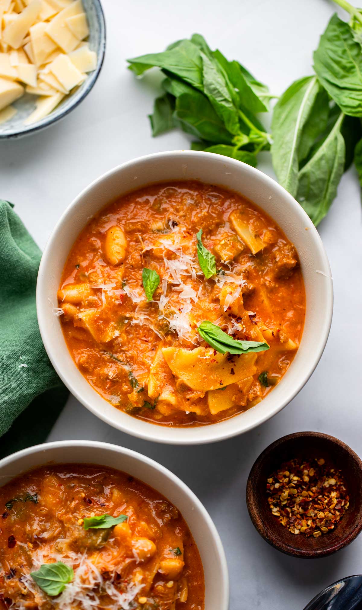 vegan lasagna soup in a bowl garnished with fresh basil.
