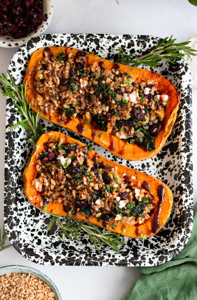 vegan stuffed butternut squash garnished with parsley in a serving dish.
