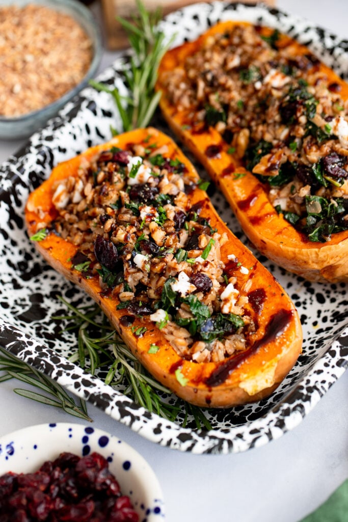 vegan stuffed butternut squash topped with balsamic glaze in a serving dish.