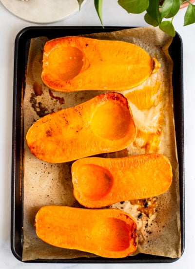roasted halved butternut squash on a baking sheet.