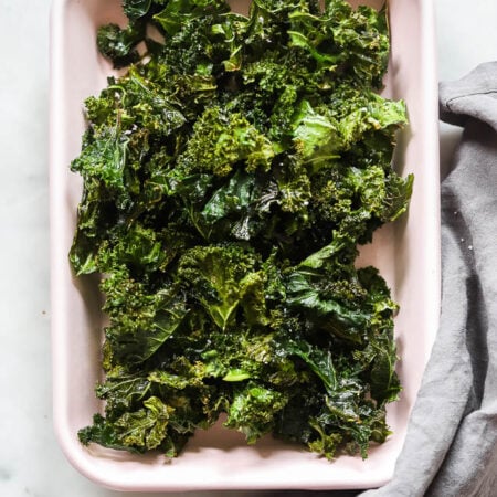 oven baked kale chips in a pink tray.