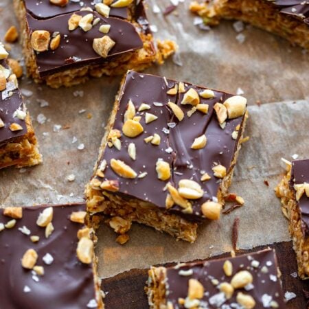 no bake peanut butter oatmeal bars cut into squares on a piece of parchment.