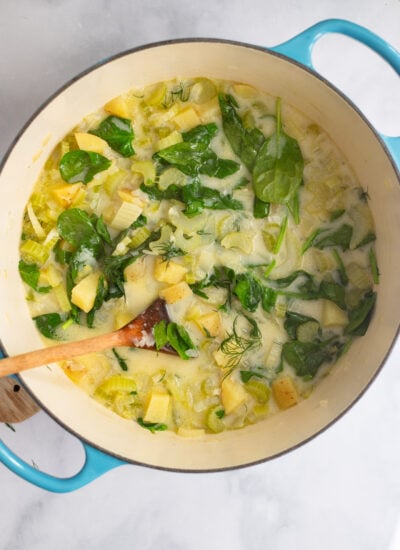 celery, onions, spinach, and potatoes cooked in coconut milk and broth in a dutch oven.