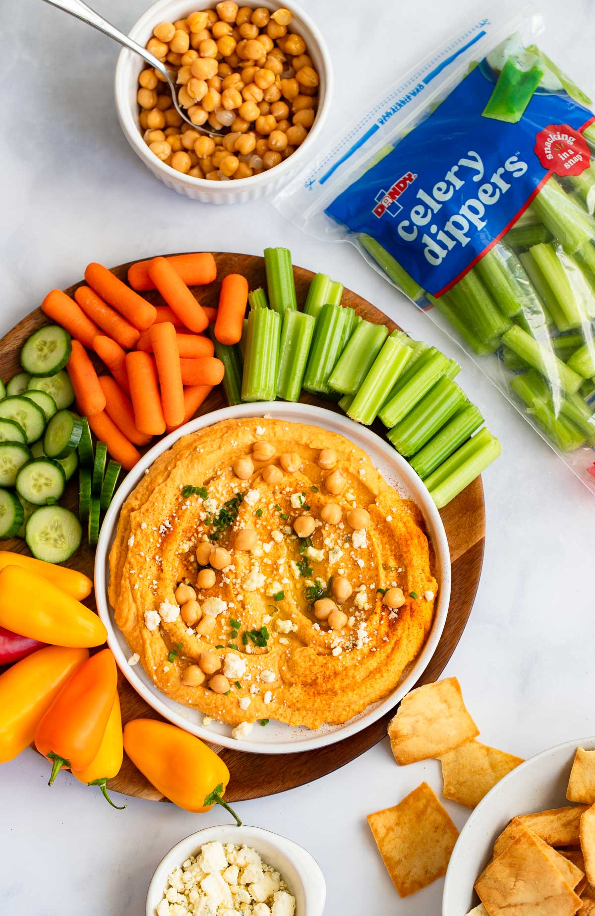 buffalo hummus in a bowl with cut veggies on the side. 