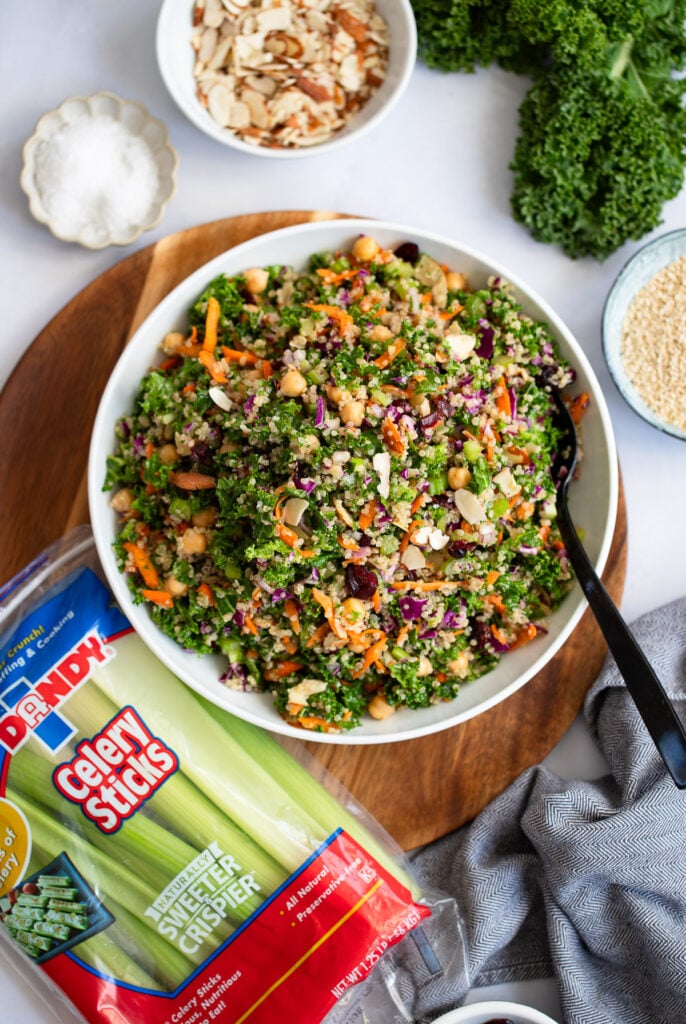 kale and quinoa salad in a serving bowl with a spoon. 