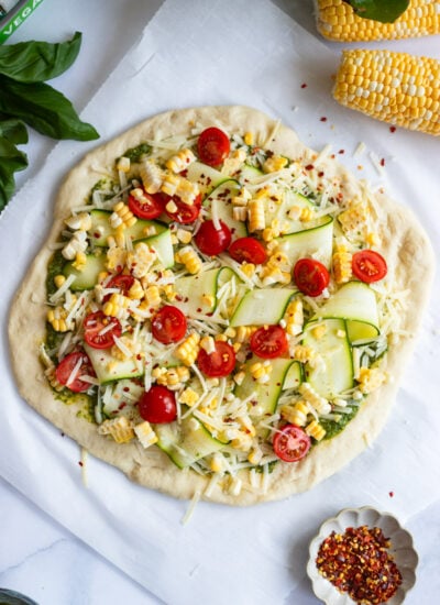 unbaked pizza with the cheese, and veggie toppings added.