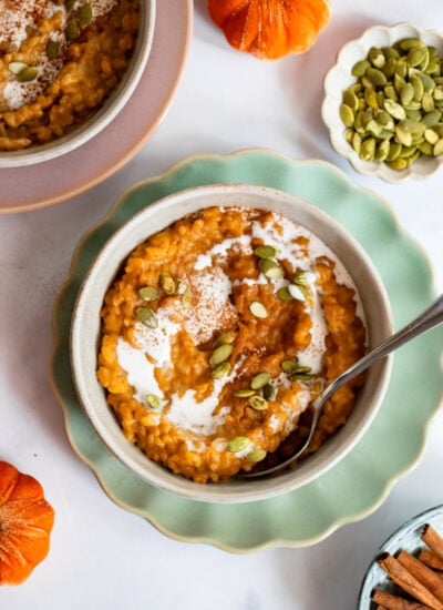 pumpkin spice rice pudding in a bowl topped with pumpkin seeds
