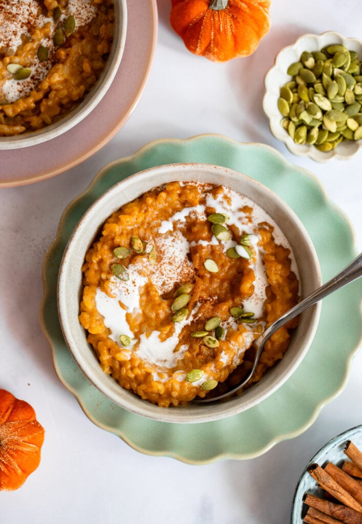 pumpkin spice rice pudding topped with pumpkin seeds in a bowl. 