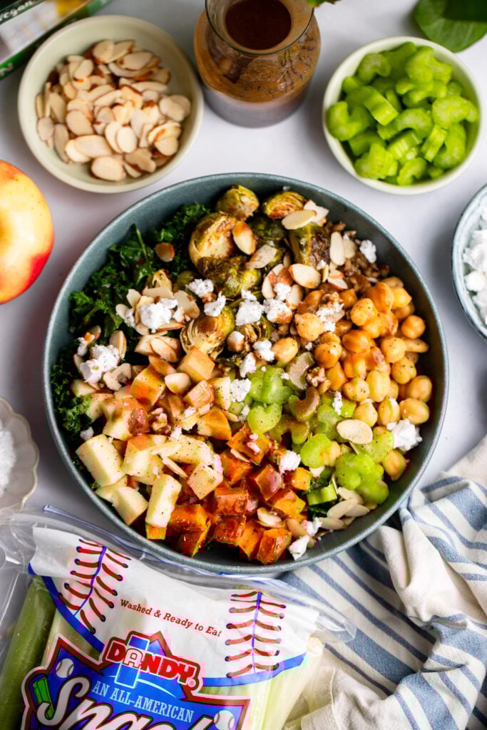 fall harvest bowl topped with celery, feta, apples, and kale.