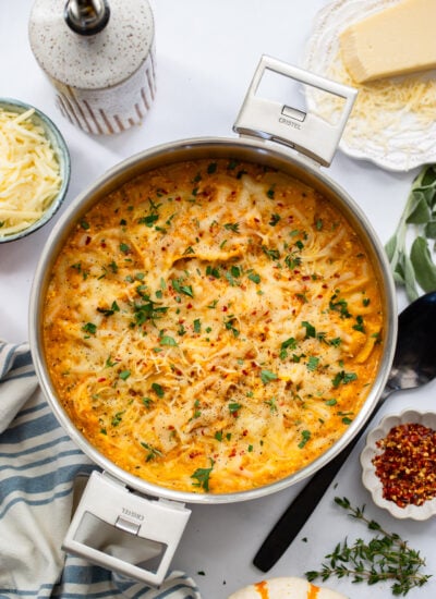 baked skillet lasagna on a white background with a serving spoon