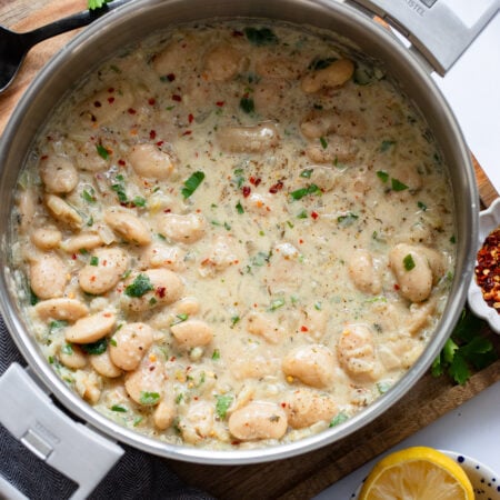 creamy parmesan butter beans in a skillet with tall sides