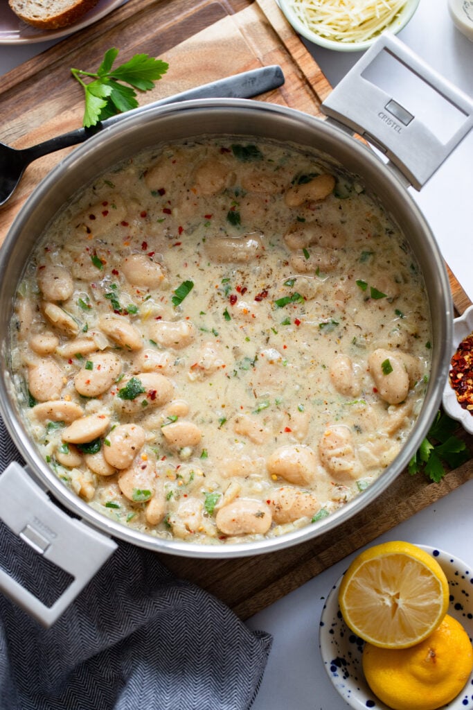 creamy parmesan butter beans in a skillet with tall sides