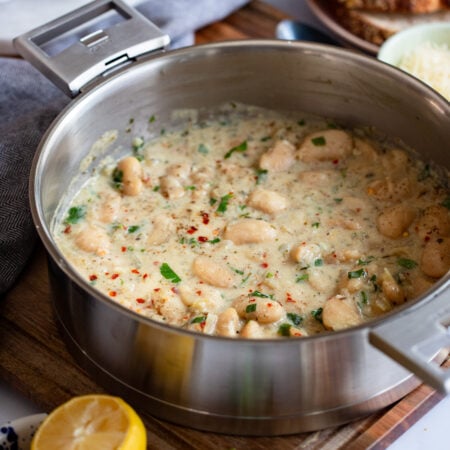 creamy butter beans in a skillet with tall sides.