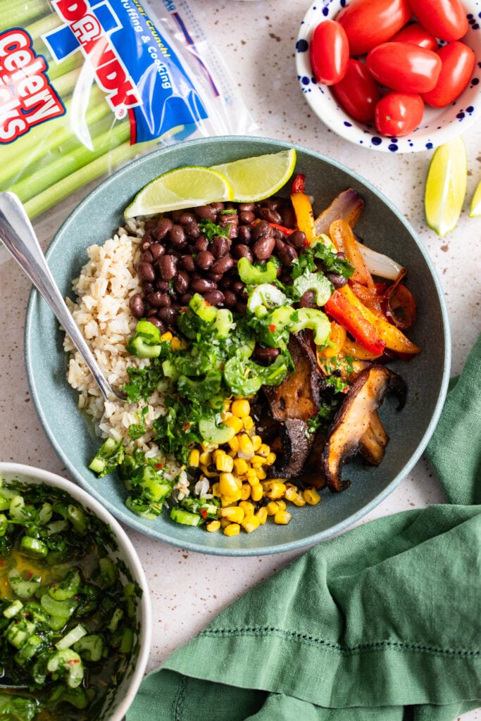 fiesta bowls ingredients plated in a blue bowl topped with chimichurri