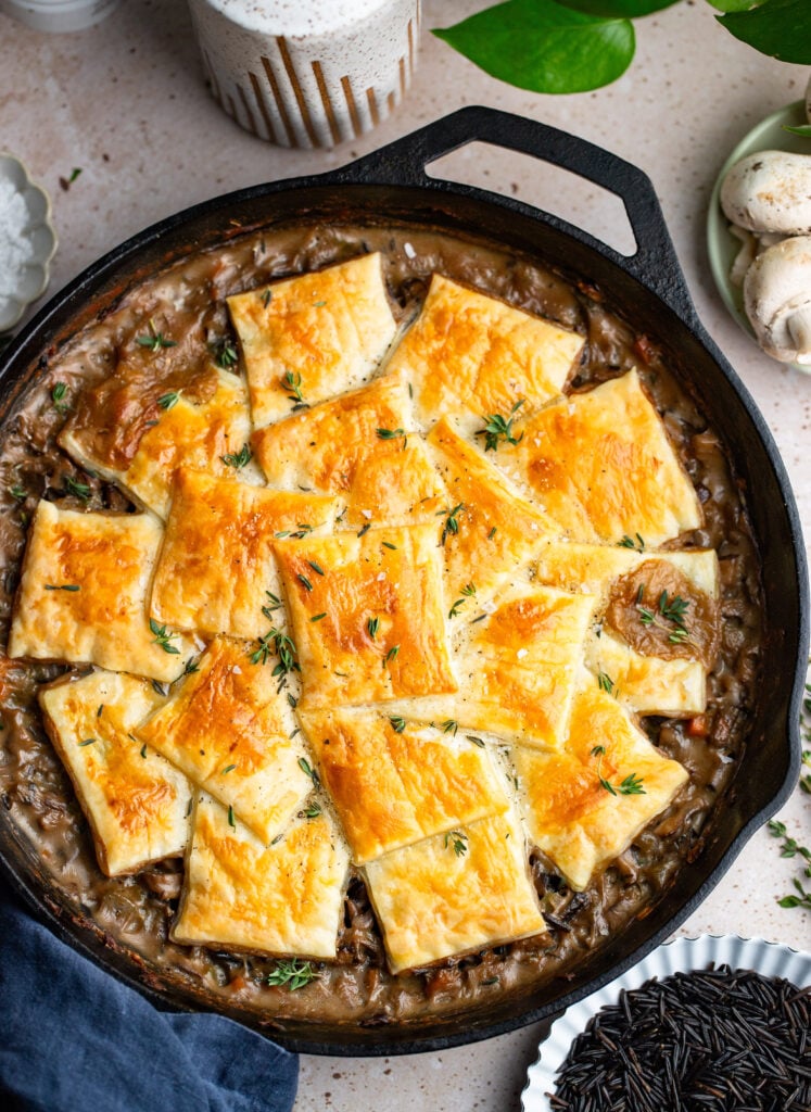 mushroom pot pie topped with puff pastry in a cast iron skillet. 