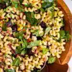 Mediterranean pasta salad in a large wooden serving bowl.