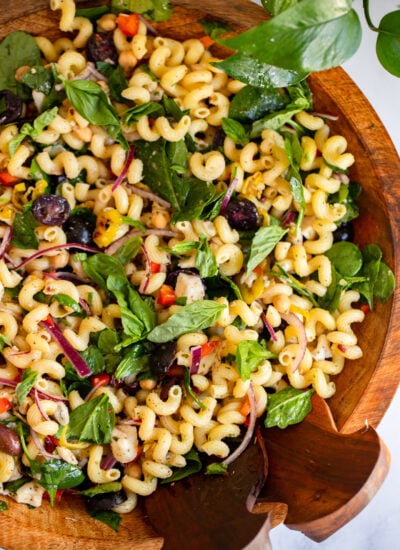 Mediterranean pasta salad in a large wooden serving bowl.